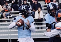 a football player is throwing the ball to another player